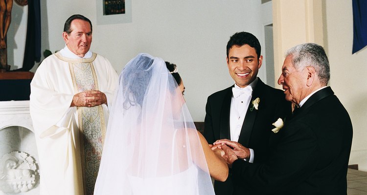 Father of the Bride Gives her Hand in Marriage to the Groom at the Altar