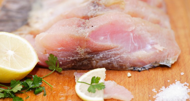 Fresh white fish fillets on chopping board