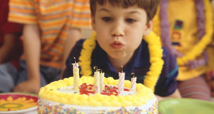 Boy at party, blowing out birthday candles