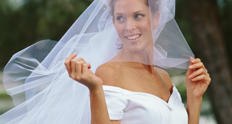 side profile of a bride holding her veil