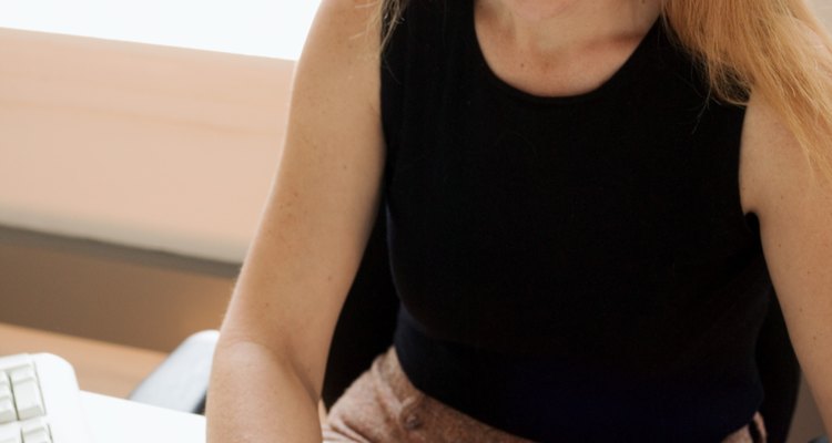 Woman writing check in office