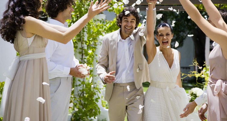 Wedding party tossing petals on bride and groom