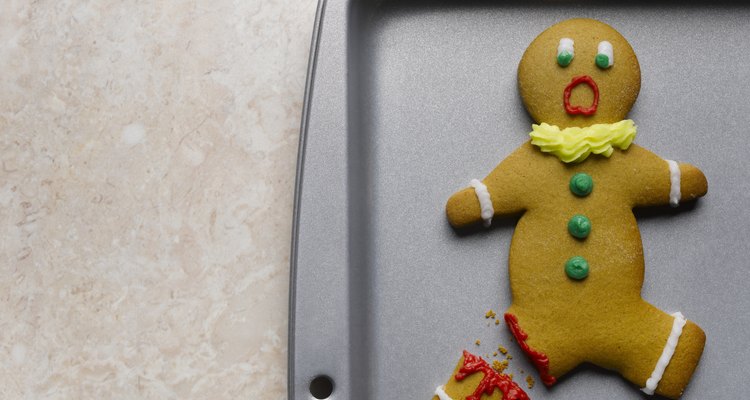 Gingerbread man with broken leg on baking sheet, close-up