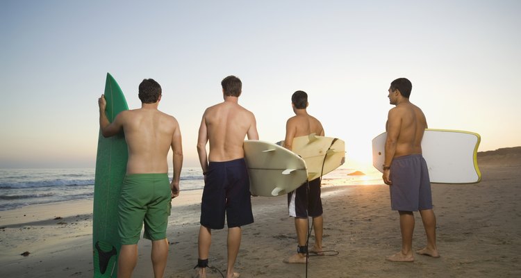 Rear view of multi-ethnic surfers