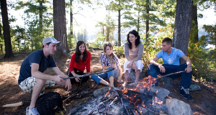 Five friends sitting around campfire