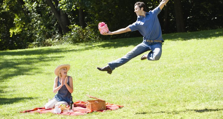 Man giving woman present at picnic in park