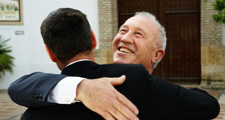 Two men embracing outdoors, smiling