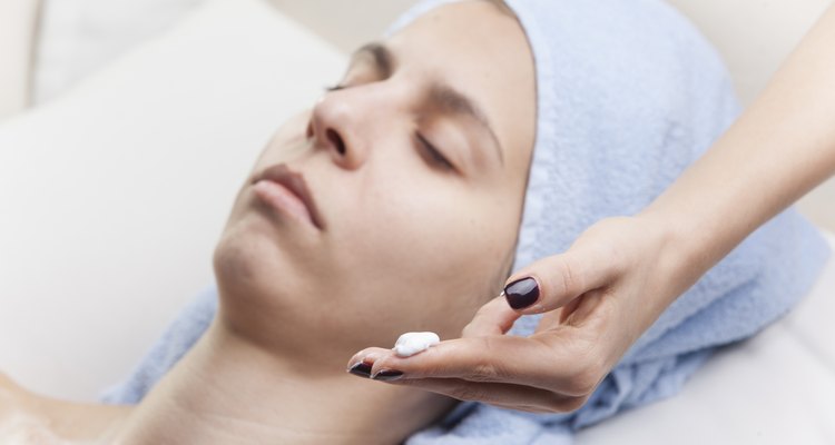 woman applaying facial mask to girl