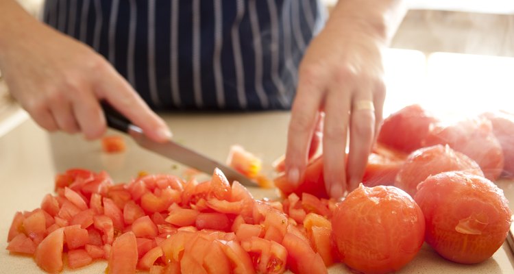 Miembros del personal de cocina preparan los alimentos antes de cocinarlos.