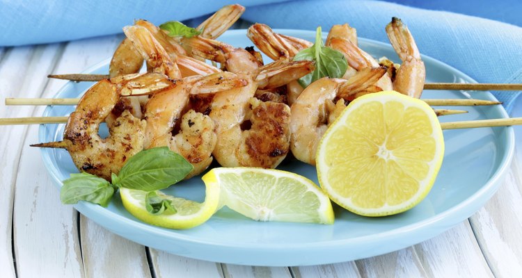 shrimp grilled on wooden skewers with lemon and basil