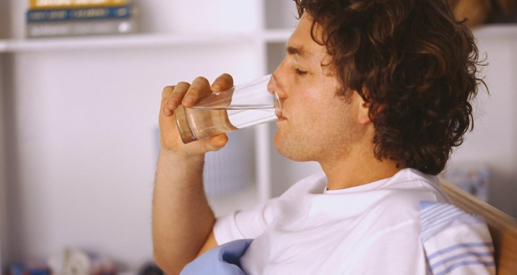 Side profile of a man drinking water in bed