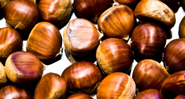 Calentar las castañas sin amontonarlas antes de molerlas hará que las cáscaras se desprendan  mejor.