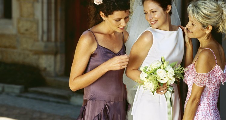 bride standing outside a church with her mother and a bridesmaid