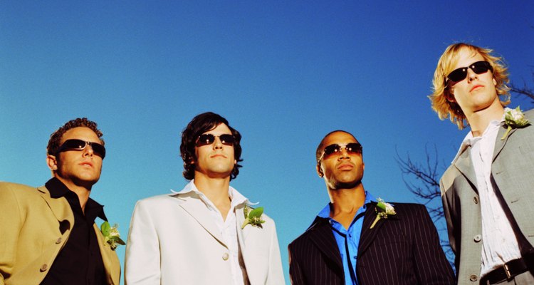 low angle view of men in formal suits wearing corsages and sunglasses
