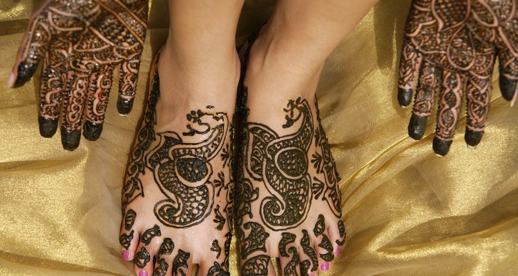 Woman with ornate henna design on feet and hands