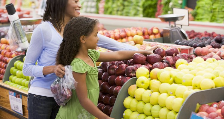 Woman and daughter shopping for apples at a grocery store