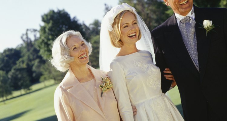 Bride with mother and father in park, portrait