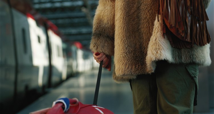 Woman with luggage, rear view, mid section