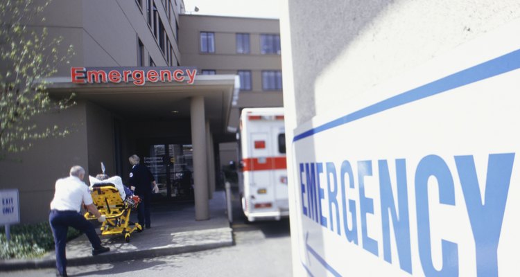 Orderly pushing patient on stretcher into emergency entrance