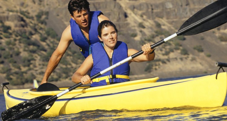 Una pareja agotada remando un kayak.