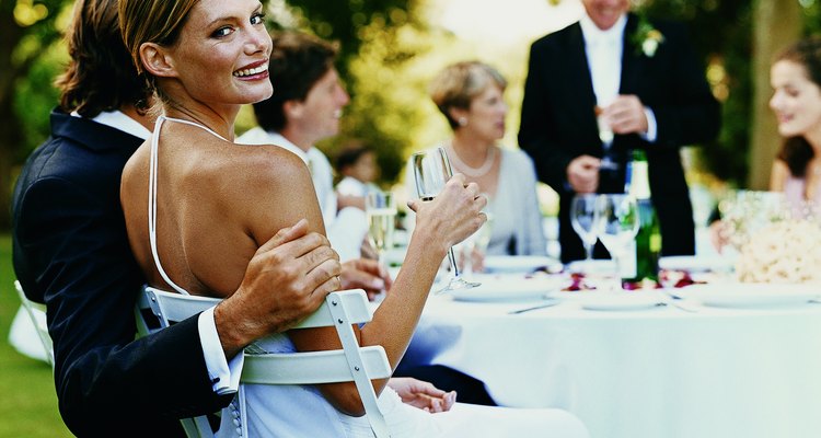 Portrait of a Bride Sitting at a Wedding Reception in a Garden With a Glass of Champagne