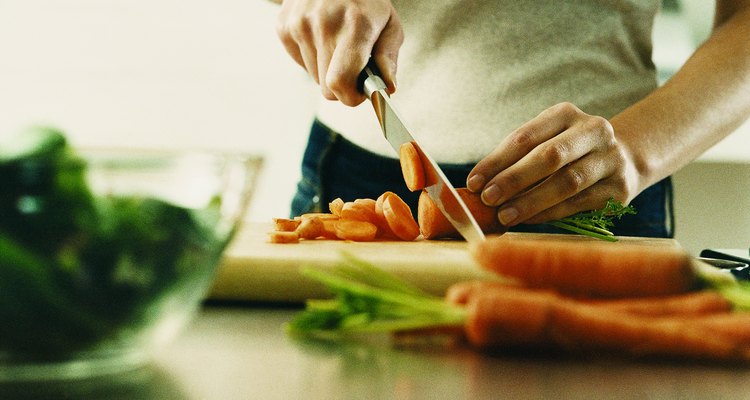 Mujer cortanto las zanahorias.