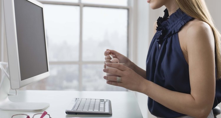 Businesswoman at desk eating yogurt