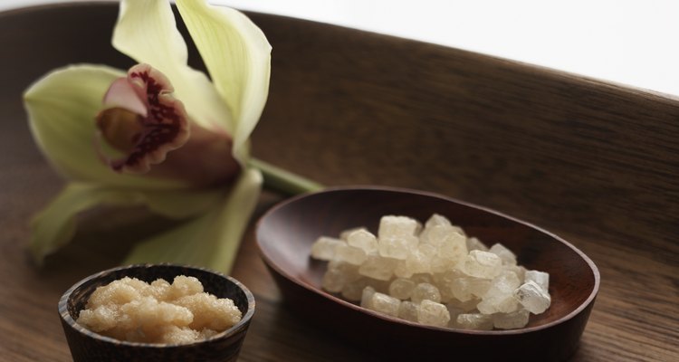 Amber sea salt, sugar scrub and orchid on tray (focus on sugar scrub)