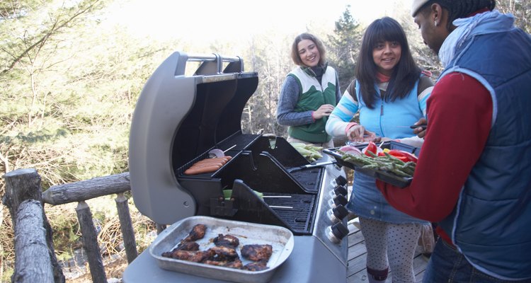Young people grilling food on porch