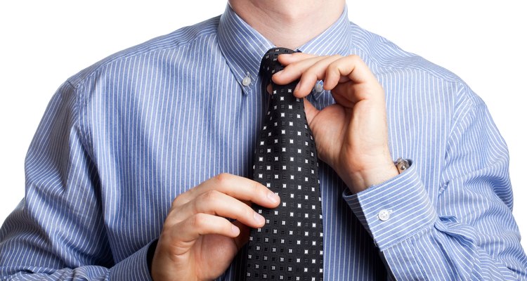 Man adjusting tie