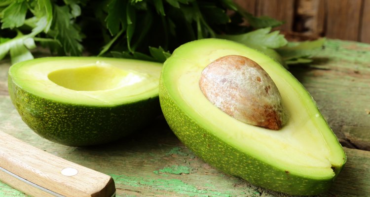 ripe avocado cut in half on a wooden table