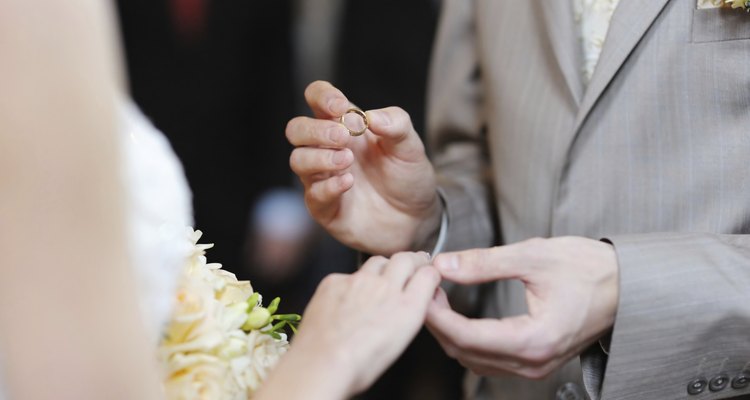 Groom putting a ring on bride's finger