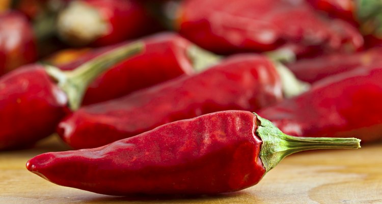 Dried cayenne red pepper on wooden surface selective focus