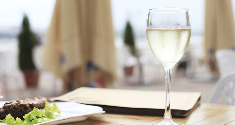 Una copa de vino blanco en la terraza de un hotel.