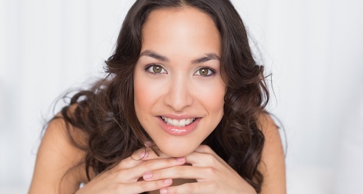 Close-up of a smiling pretty brunette in bed