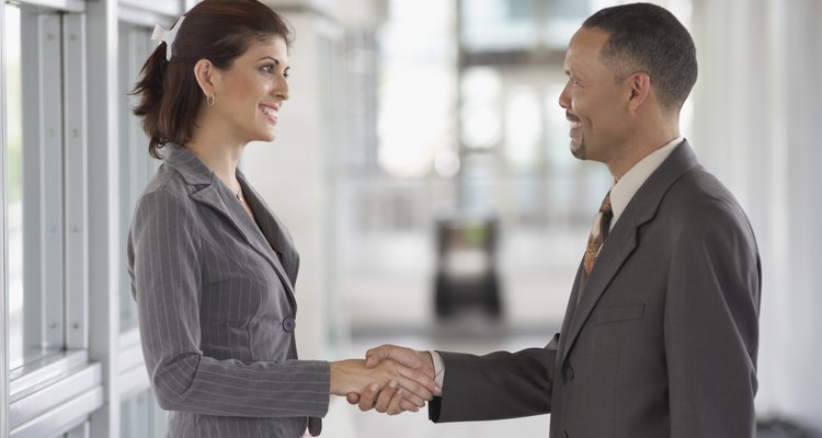 Side profile of a young woman and a mature man shaking hands