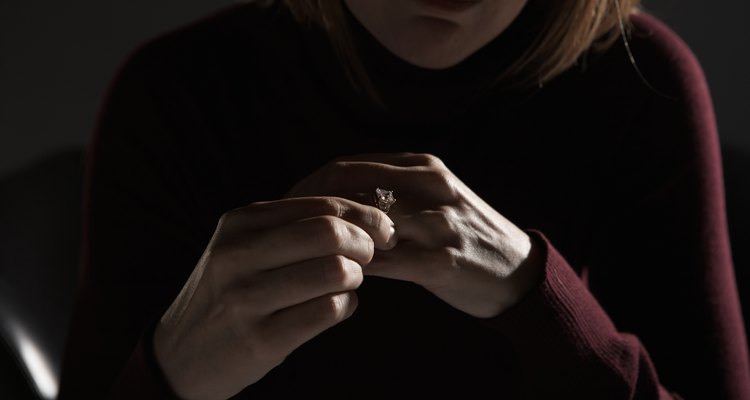 Woman adjusting wedding ring, mid section (focus on hands)