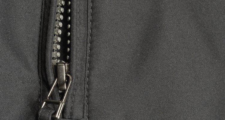 Black polyester twill fabric texture background, open jacket zipper closeup