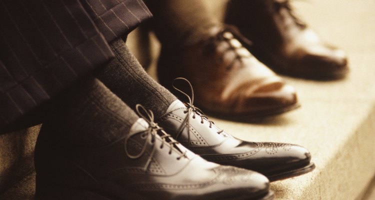 Two businessmen sitting on steps, Close-up of feet