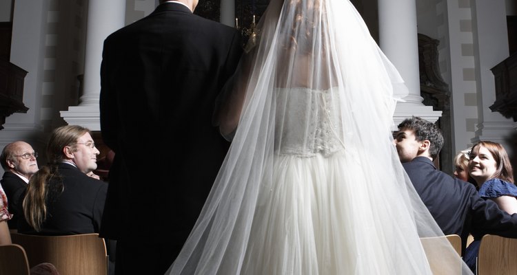 Father walking bride down church aisle, rear view