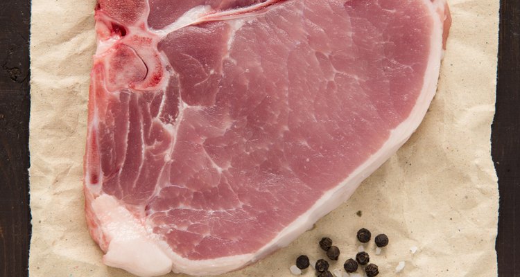 Raw pork chop steak on wooden background