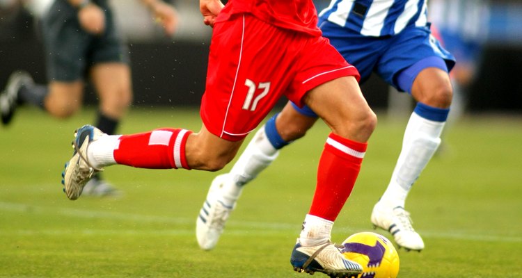 Jogador de futebol correndo com bola