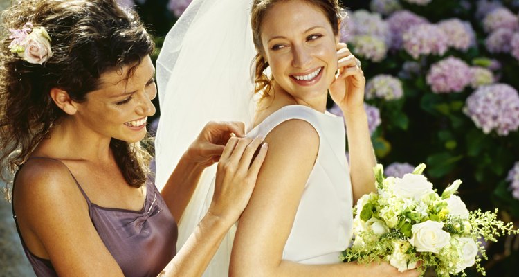 bridesmaid adjusting the bride's wedding gown