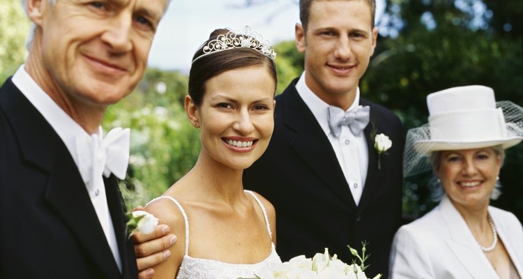 portrait of a newlywed couple standing with their parents