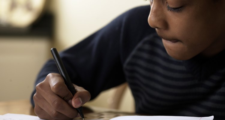 Close-up of boy (12-13) doing homework at desk