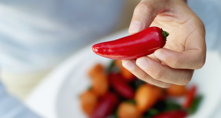 Woman holding a red chilly in her hand