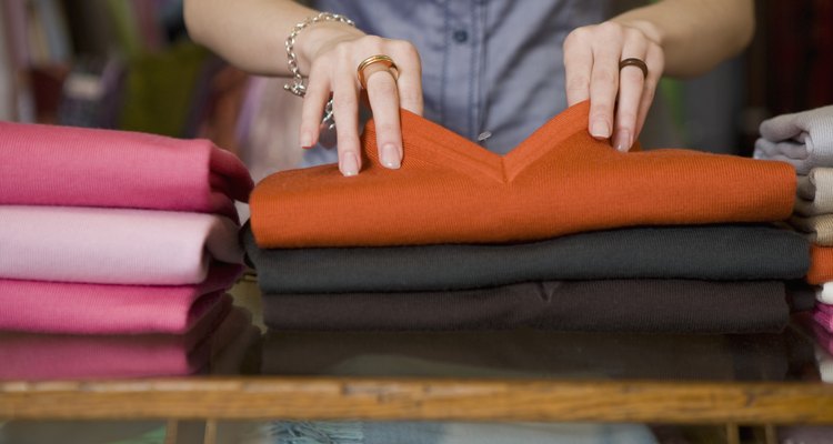 Woman folding clothes in store