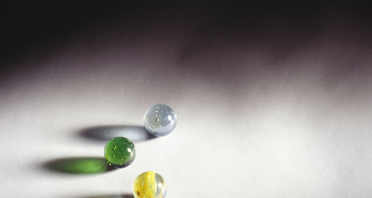 Thread marbles by drilling holes through them.