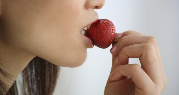 Close Up Image of a Woman Eating a Strawberry, Side View