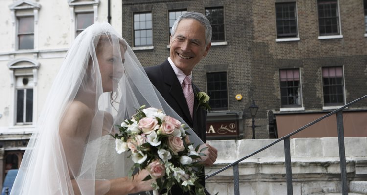 Father escorting bride up steps to church, smiling, close-up